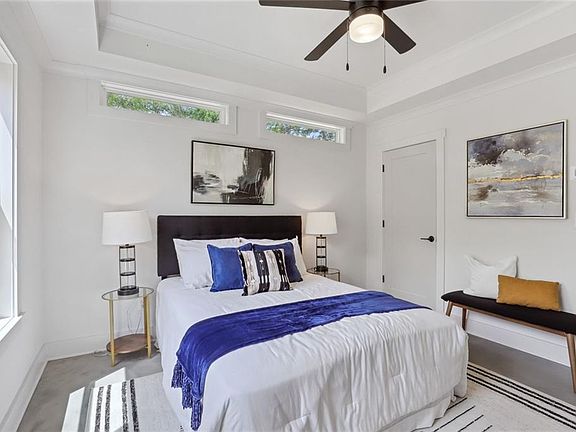 primary bedroom with lots of natural light via two windows and two additional transom windows