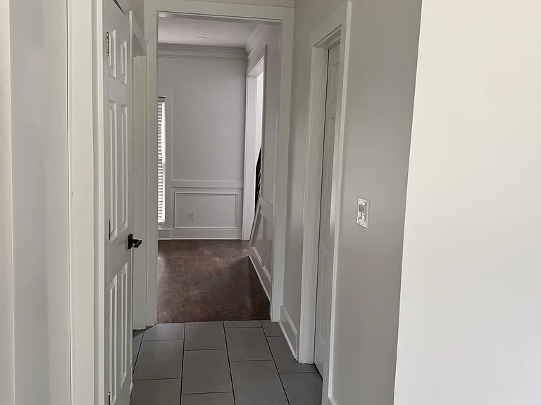 Hallway from kitchen leading to bathroom, garage, and formal dinning room.
