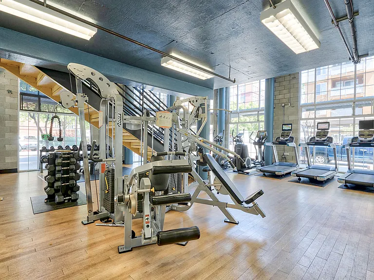 The downstairs of our bi-level fitness room features free weights and cardio equipment
