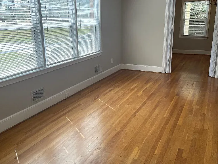 Large living and dining room with hardwood floors on the front part of the house, with a lovely view.