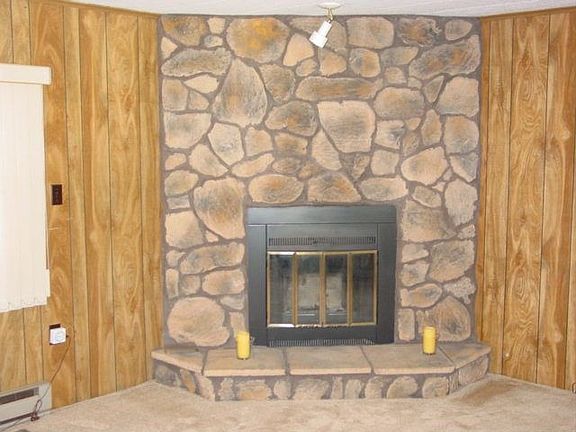 living room with stone fireplace