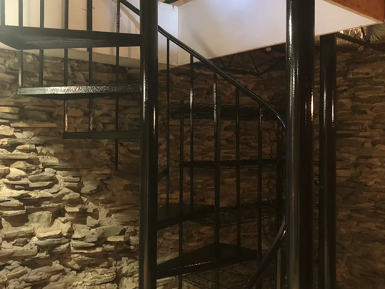 Spiral staircase leads to bedroom, full bathroom, and upstairs landing space