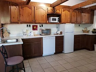 Entry room kitchenette leads to main deck (with propane burner and BBQ grill) and living room. Fridge/freezer, dishwasher, washer/dryer, optional microwave, air fryer, electric griddle, rice cooker, crock pot, toaster, blender, dishes, utensils, etc.
