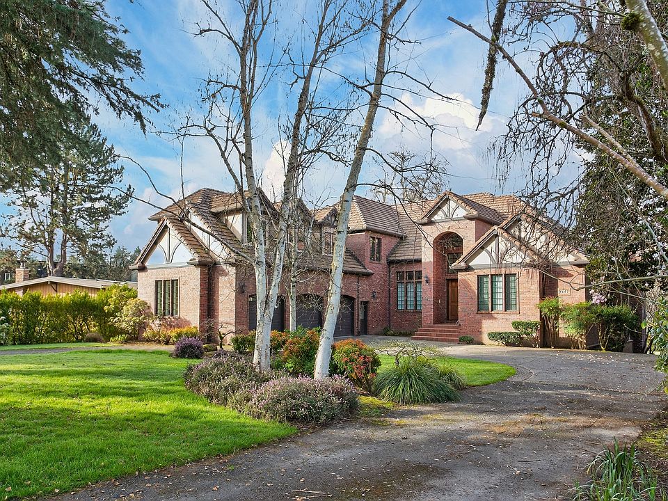 Timeless brick Tudor waterfront estate on 0.75 acres _ elegant curb appeal with private driveway and lush landscaping
