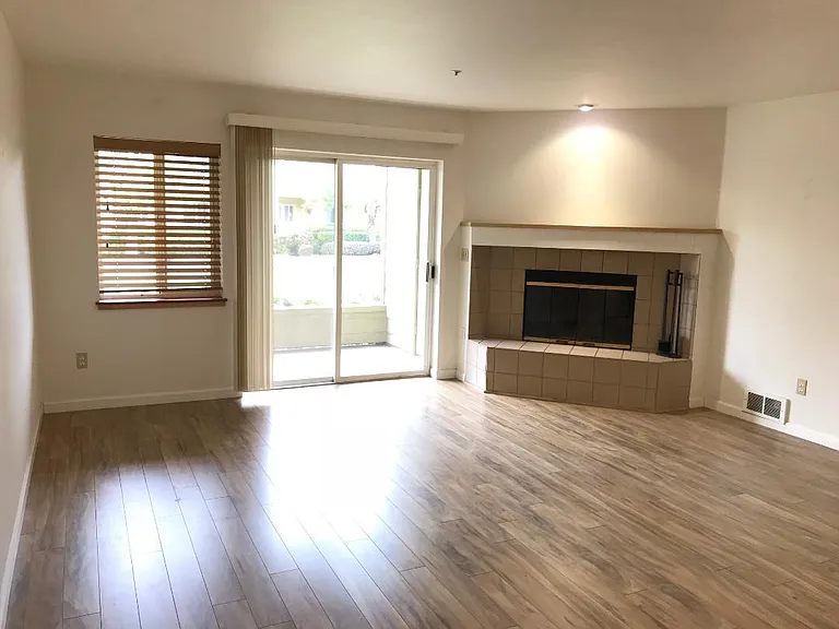 Living room, looking onto covered patio. Wood burning fireplace.