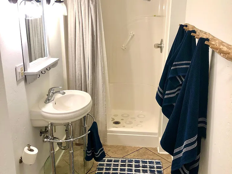 Large spacious bathroom with new lighting and bathroom fixtures.