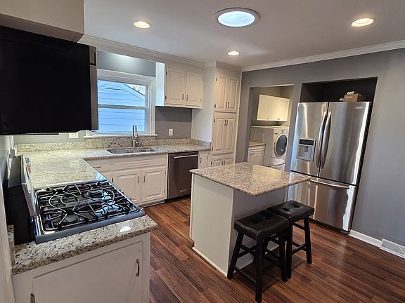 Kitchen with granite countertops, convection gas range, dishwasher, refrigerator and microwave