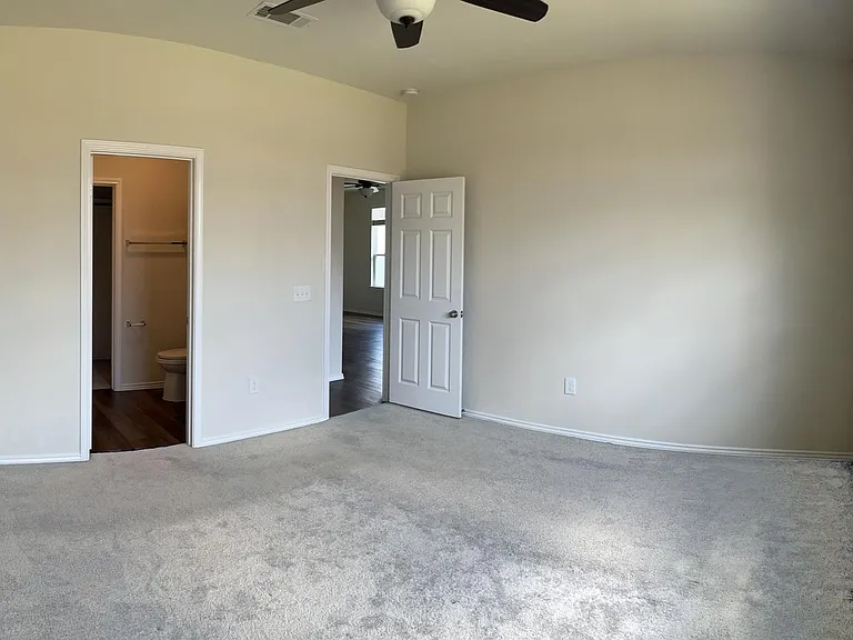 Master bedroom with plush carpet, remote controlled ceiling fan with lighting with in-suite bathroom and walk-in closet