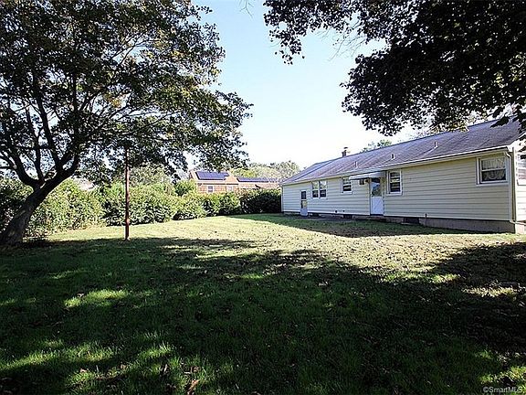 Pretty backyard with shade trees and plenty of space for recreation.