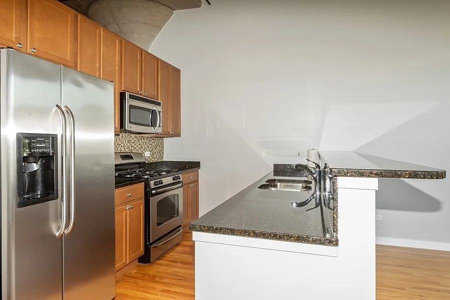 Kitchen with granite counters, stainless appliances & 42" cabinets.