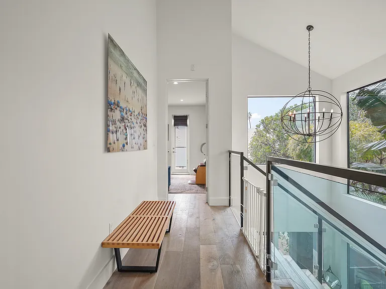 A long bright hallway separates three bedrooms upstairs