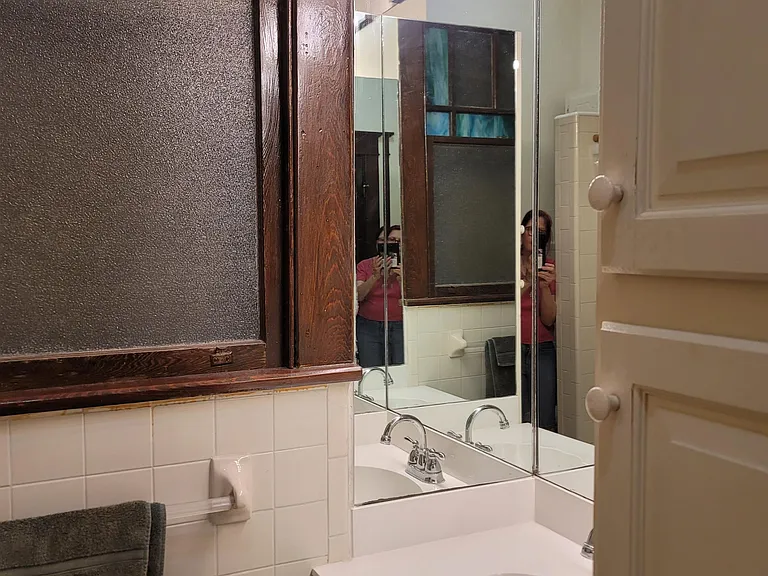 Lucky you to have these wraparound mirrors around the sink and the Arts and Crafts stained glass at the window.