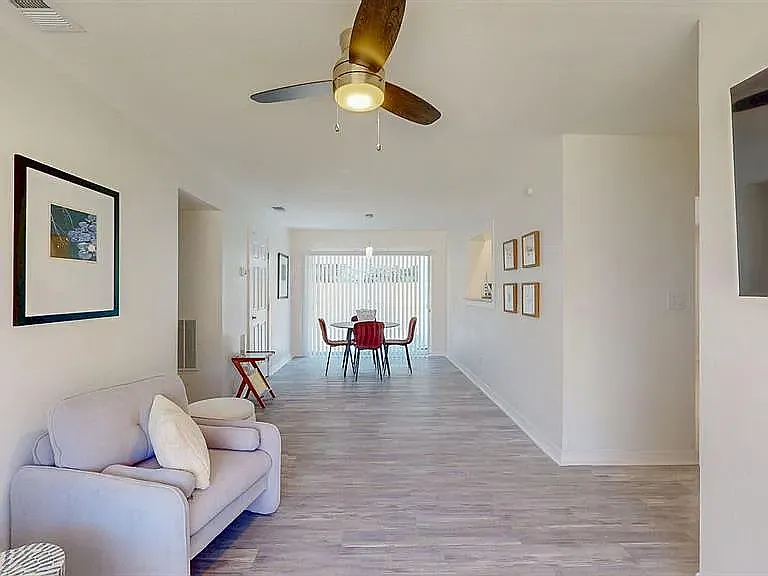 Dining area with round wood table, modern chairs, pendant lighting, and sliding door to the backyard