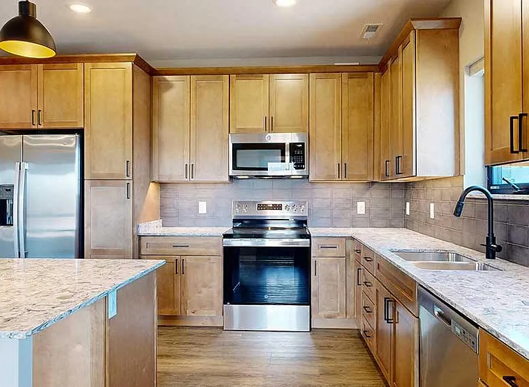 Gather and entertain in this spacious kitchen and dining area, featuring warm cabinetry and high-end finishes.
