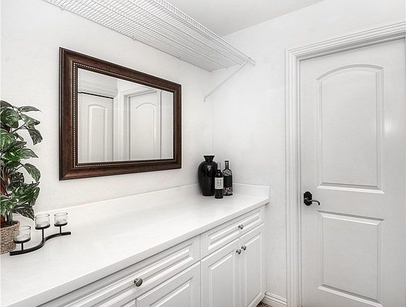 Laundry Nook with Plenty of Space to Fold, Hang, and Store Your Fashionable Items. The Door leads to a Spacious Powder Room that Makes Entertaining a Breeze.
