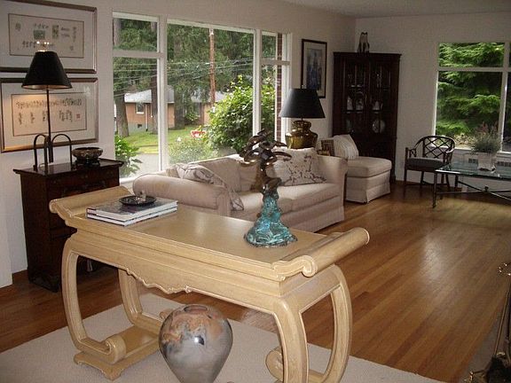 The spacious living room offers hard wood floors, large windows, a stone fireplace and plenty of roo