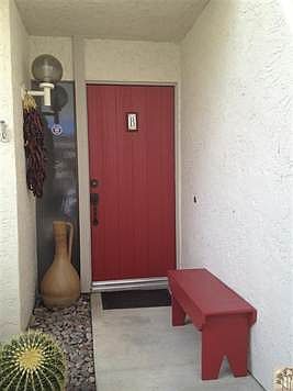 Charming entry with desert landscaping and roses.