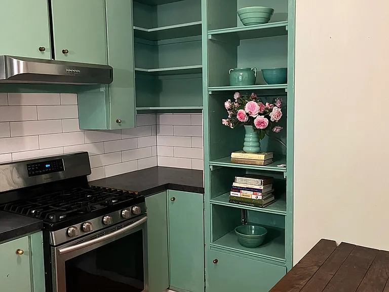 Kitchen with new range, hood and vintage campaign table.