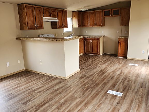 View of living room, kitchen and dining area from hall side