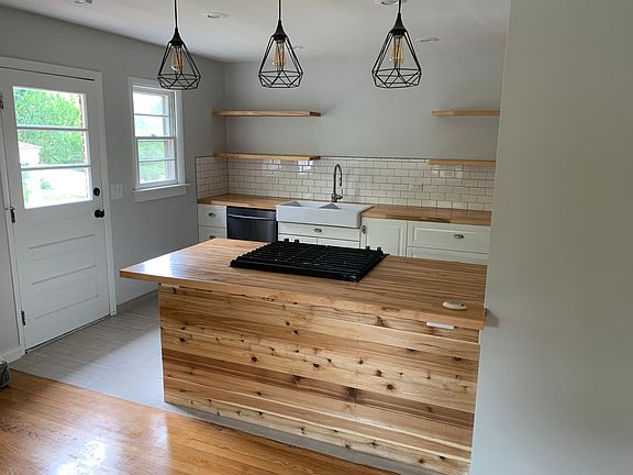 A view into the kitchen from the living room. Oak floors, cedar beneath the bar, maple butcher block counters.