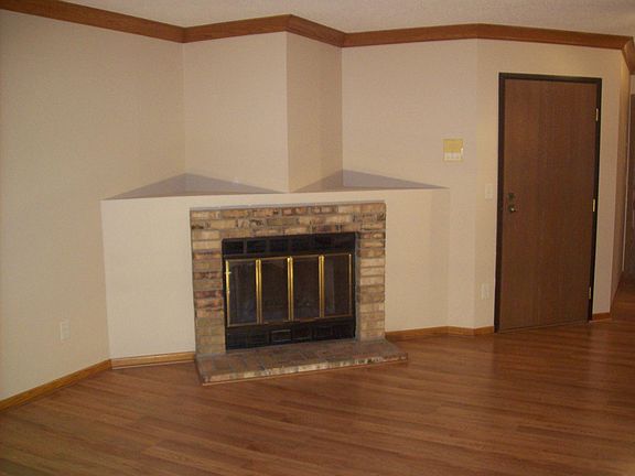 Wood burning fireplace in living room. Front door to unit is on the right.