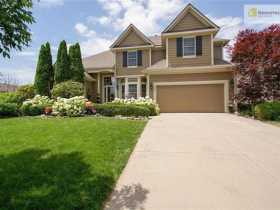 Traditional 2 Story with 2 car garage, bay window and hydrangeas in full bloom!