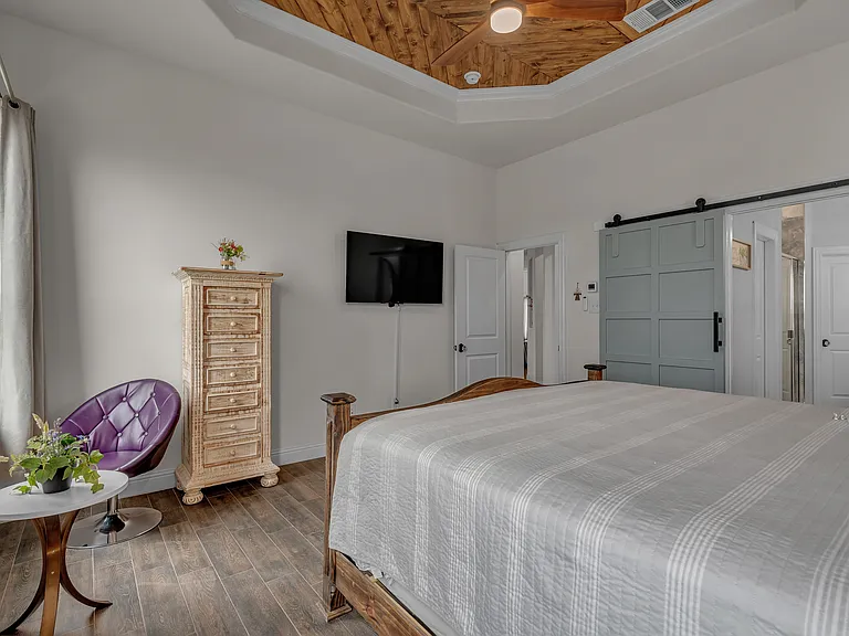 Master bedroom with a king bed, an attached master bathroom, and a large walk-in closet. Lake views from windows overlooking the backyard.