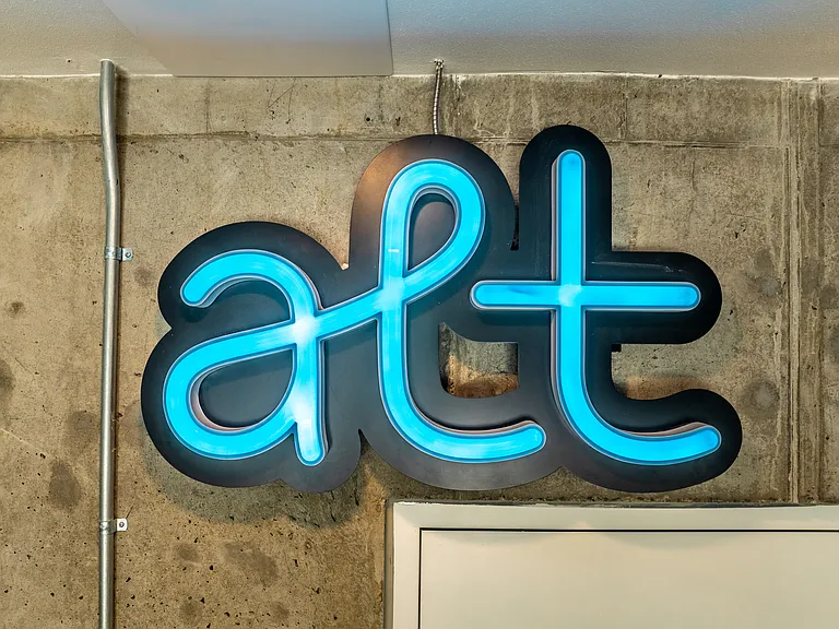 Bright neon sign that reads 'alt' at Alt Capitol Hill.