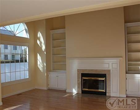 Bright living room with new maple floors and gas fireplace