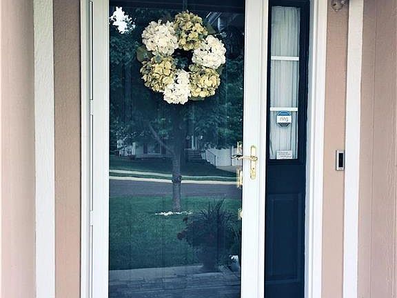 Inviting front door with tile stoop and "Ring" security bell.