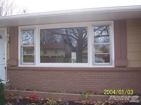 BRICK ON THE FRONT UNDER THE LARGE PICTURE WINDOW