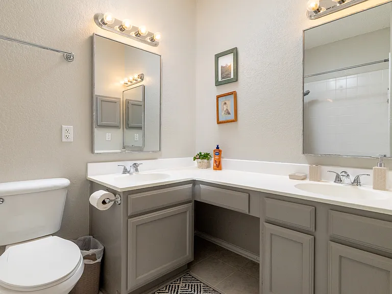 Bathroom 1 features a tub/shower combo and his-and-hers sinks on an L-shaped counter. Stocked with soap, shampoo, and conditioner for your convenience. Located on the first floor.