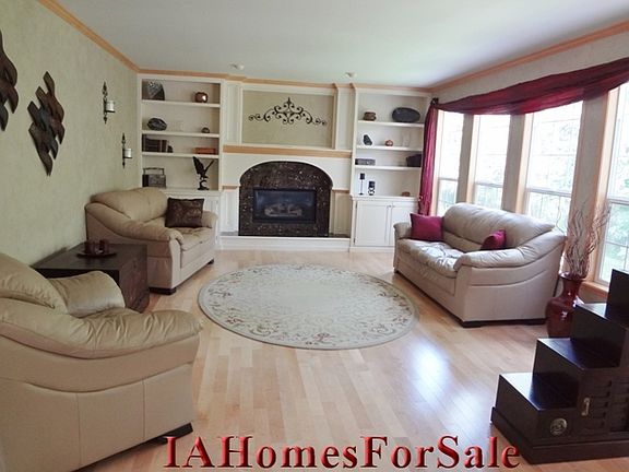 Great room with marble tiled large fireplace, wall of windows overlooks private view of woods, natural habitat to wild deer and turkey.