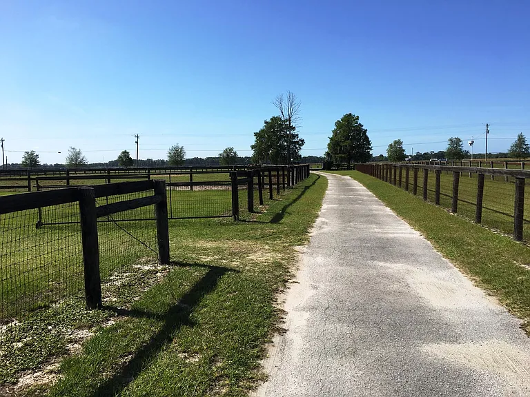 View down paved driveway to Gated entrance and Road