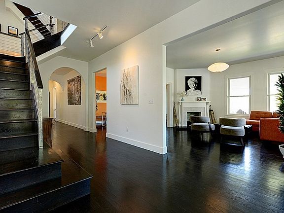 Front entry, main staircase, living room and central hallway that leads to dinning area, den and kitchen. Ebony stained Oak hardwoods throughout most areas. Ten foot ceilings on the first and second levels.