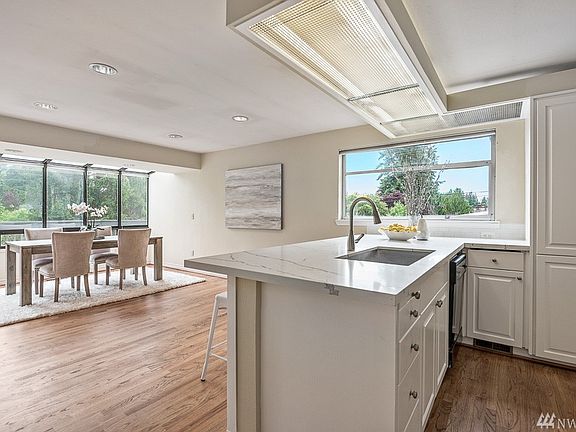 Newly remodeled kitchen with quartz countertops, opens to the sunny dining room / sunroom.