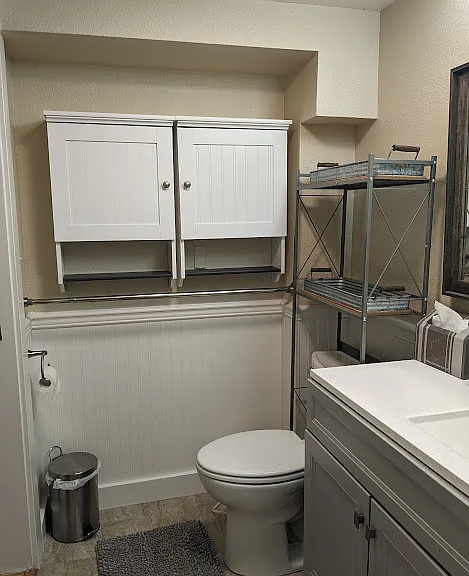 Downstairs bathroom storage and towel rack.