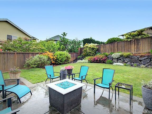 The patio area is enveloped in lawn space and a waterfall, tucked in the corner is a lovely accent. 