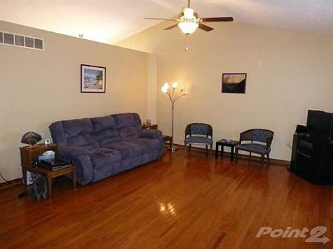 Living room with hardwood floors, ceiling fan and cathedral ceilings.