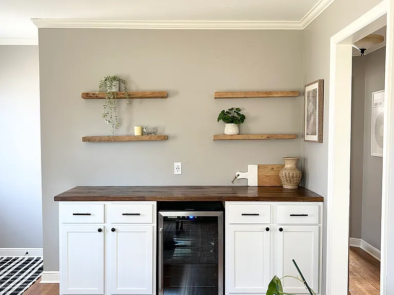 Living room dry bar with extra storage space and a mini fridge.