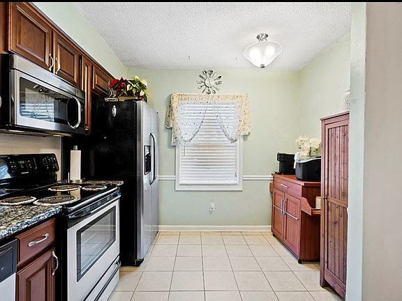 Bar cart has been replaced with a table and two chairs for this eat in kitchen.