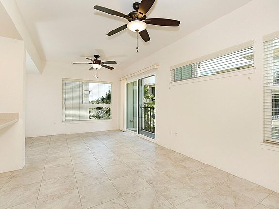 Living room facing the entrance. Lanai to the right. Lots of windows for natural light. All window coverings included.