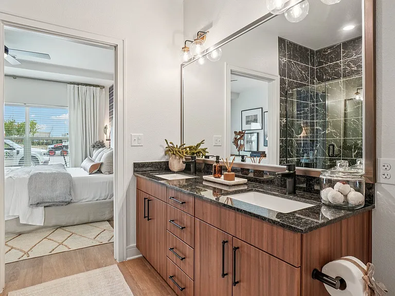 Bathroom with Granite Countertops, Double Vanity Sinks, Walk-in Shower, and Walk-in Closet
