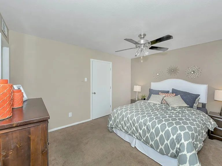 Spacious bedroom with ceiling fan and large windows