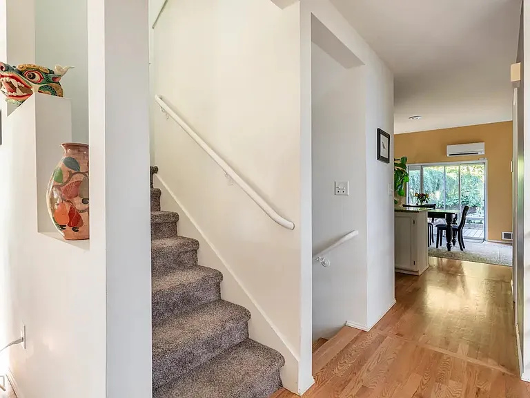 Stairs leading to upstairs bedrooms with view of back dining room and deck.