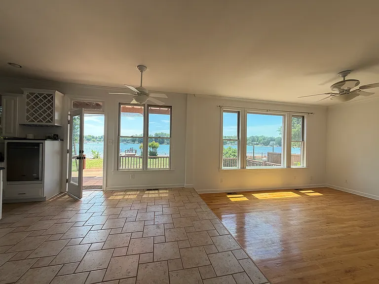 Open-concept sitting room seamlessly connected to the kitchen. Expansive windows bring stunning lake scenery indoors. Bathed in gentle natural light, this relaxing space is ideal for leisure time and family gatherings.