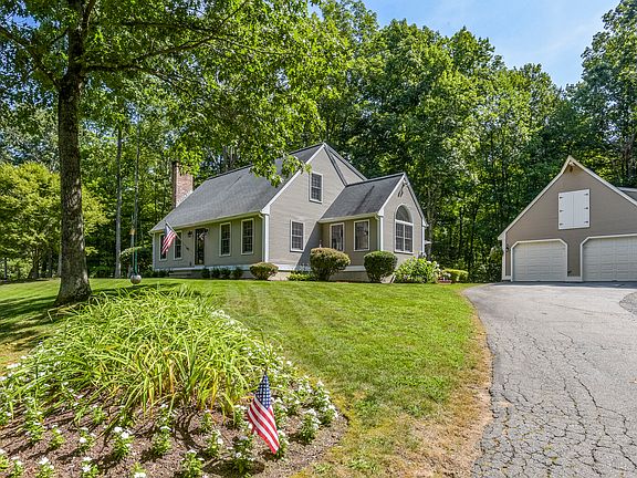 Driveway leading up to house and detached 3 car garage.
