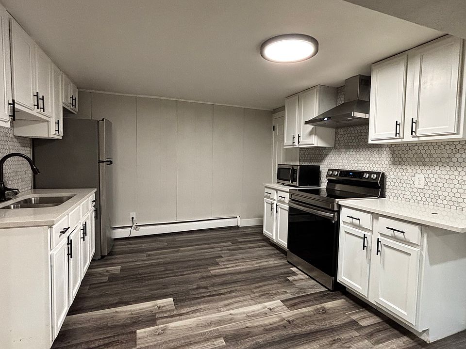 Open kitchen area with modern appliances and new hood vent