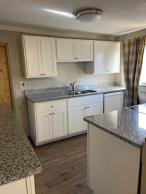 Farmhouse style kitchen with nice cabinets and granite countertops. Kitchen appliances include Stove, Dishwasher and Refrigerator.