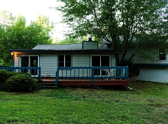 Back of house showing sunroom, deck, and master bedroom and 